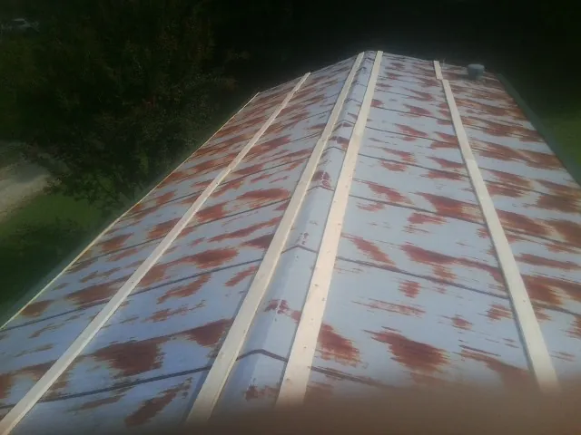 Rusted metal roof panels with new wood purlins before replacement — Storm Damage Roof Repair in Rosharon by Roofing Brothers