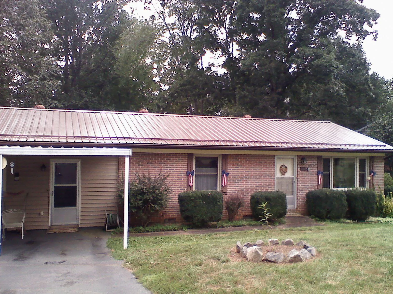 Bronze metal roof and carport on a brick ranch home — Roof Repair work by our crew in Rosharon