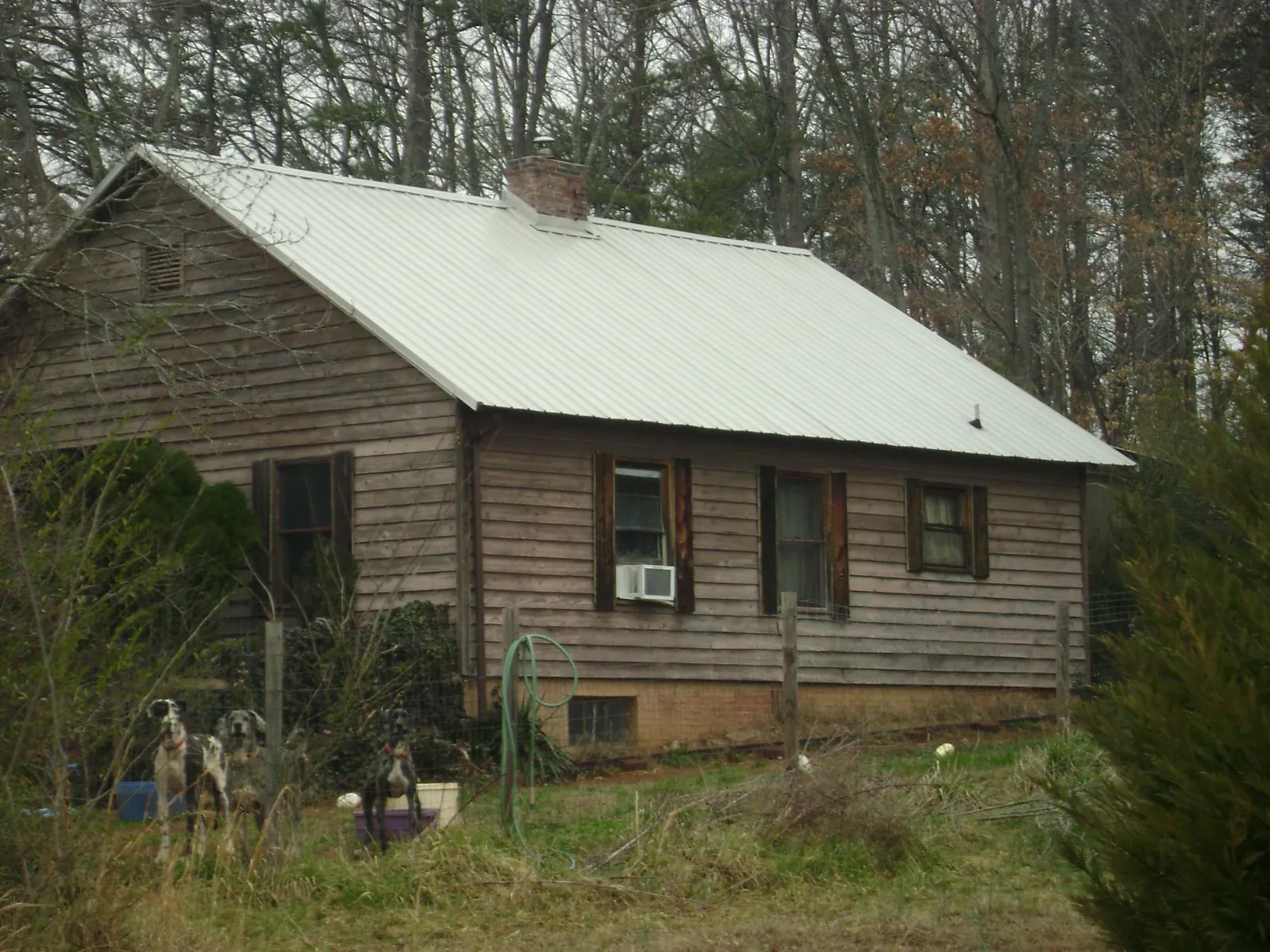 White metal roof on an old wood sided farmhouse, from a Metal Roof Installation job in Rosharon
